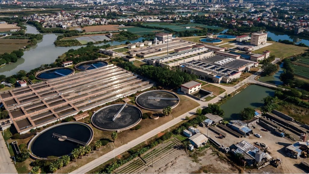 Aerial view of square and round sewage treatment tanks in a sewage treatment plant