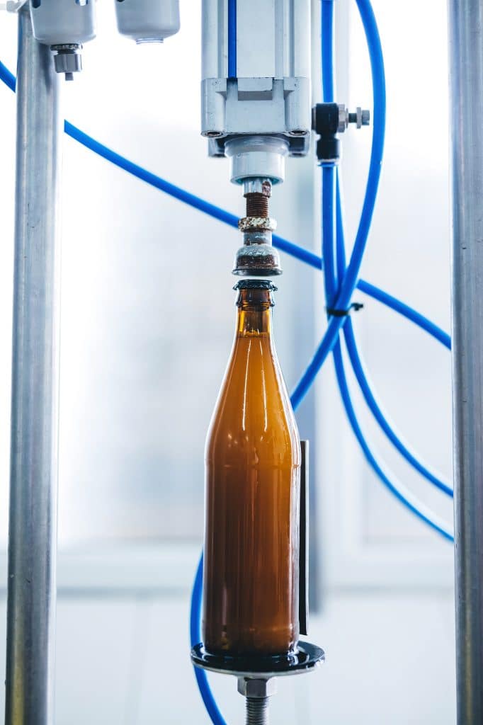 Beer bottle capping machine in brewery. Industrial